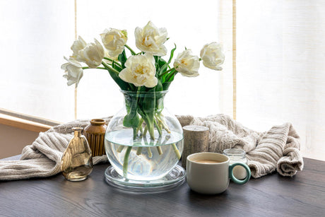 “Coffee table styled with stacked books, a decorative tray, candles, and a small plant, creating a balanced and inviting living room centerpiece.”
