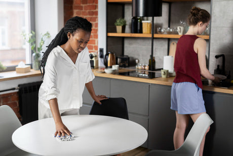 "Person cleaning and applying protective coating to a dining table, demonstrating tips for maintaining furniture quality."