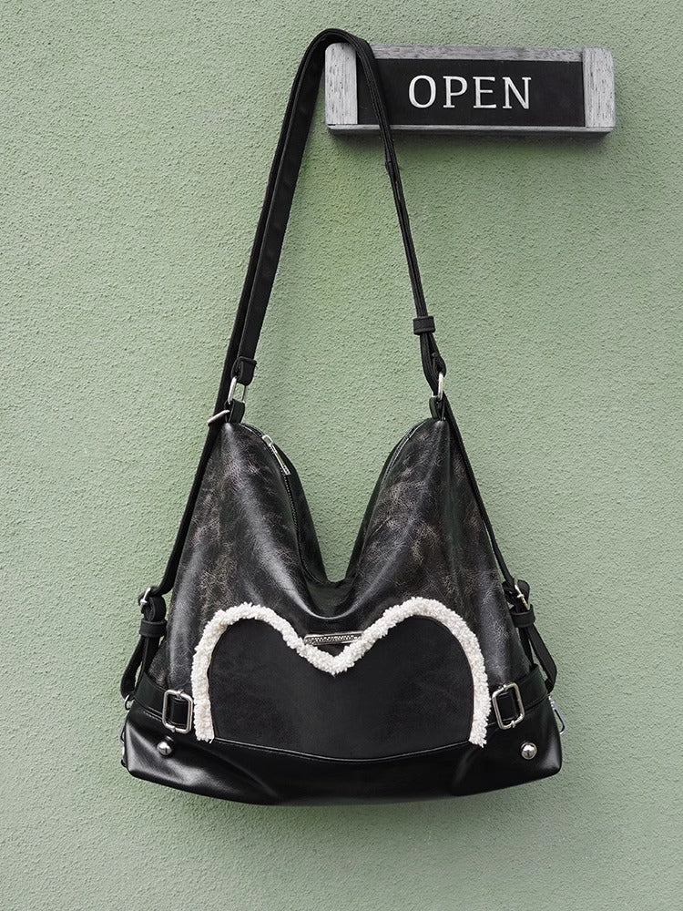 Stylish black tote backpack with heart embellishment - can be worn on one shoulder or as a backpack