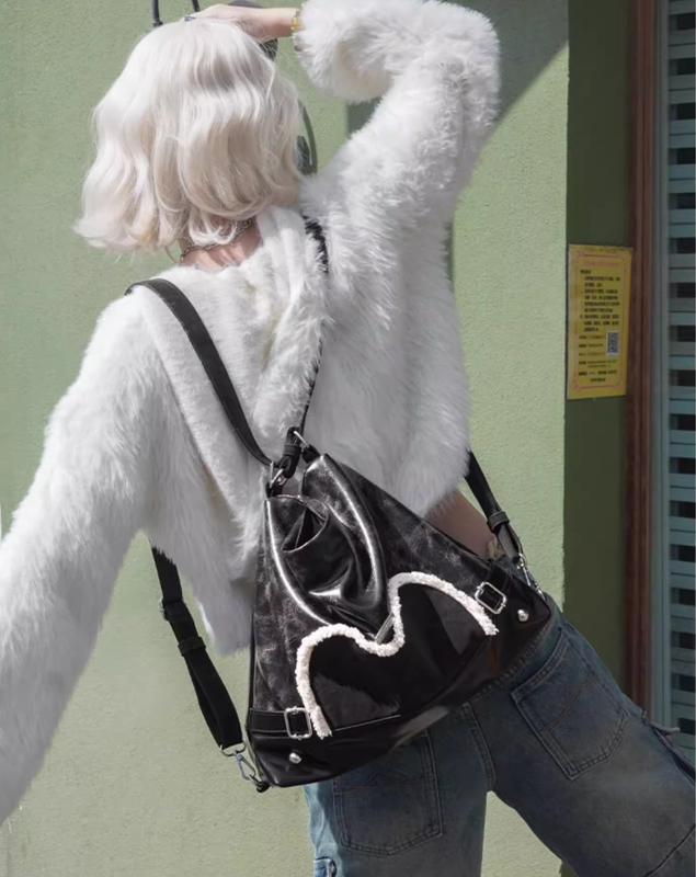 Stylish black tote backpack with heart embellishment - can be worn on one shoulder or as a backpack