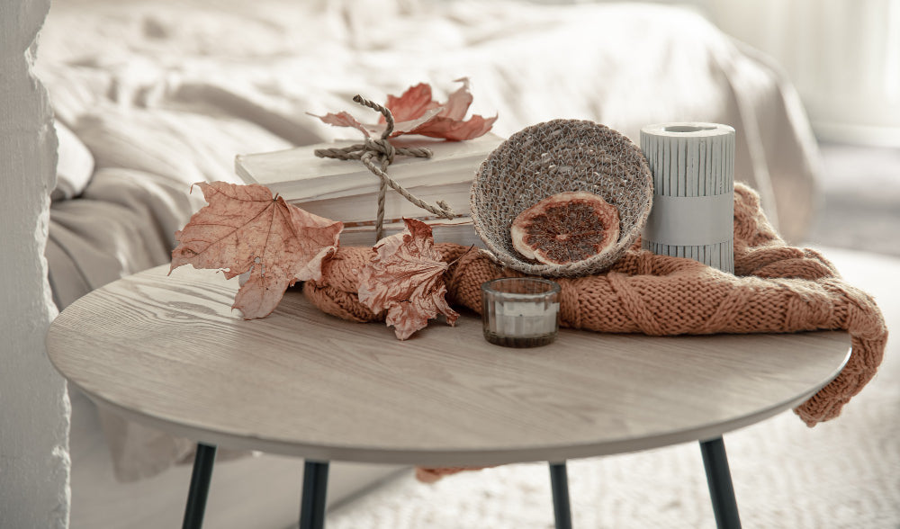 “Elegant bedside table styled with a lamp, scented candle, books, and a small plant for a cozy retreat feel.”