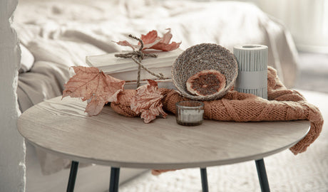 “Elegant bedside table styled with a lamp, scented candle, books, and a small plant for a cozy retreat feel.”