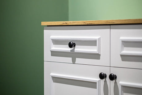 "Compact bedroom scene with a modern space-saving bedside table featuring a hidden drawer and side shelf, neatly holding books, a lamp, and essentials to maximise storage in a small area."