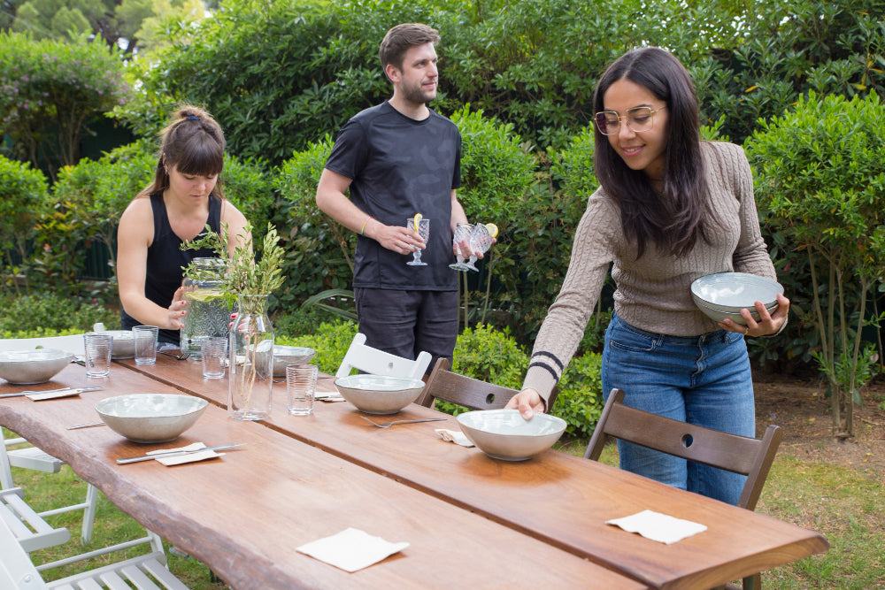 “Person constructing a wooden outdoor table using pre-cut timber, drill, and screws in a backyard DIY project.”