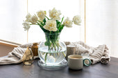 “Coffee table styled with stacked books, a decorative tray, candles, and a small plant, creating a balanced and inviting living room centerpiece.”