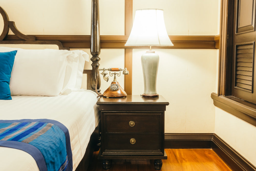 "Two bedside tables side by side — one made of natural wood with a warm, textured finish and the other crafted from sleek metal with a matte black frame — showcasing durability and style differences."