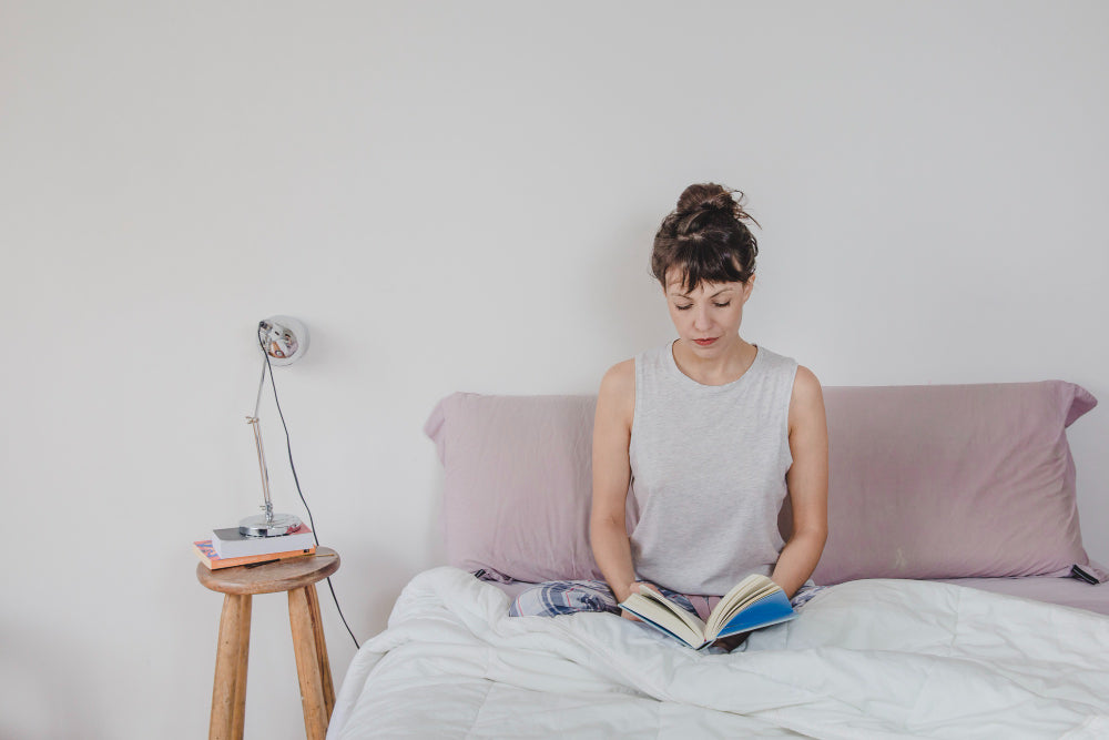 “Grey upholstered bed paired with white and natural wood bedside tables, creating a soft and balanced bedroom color palette.”