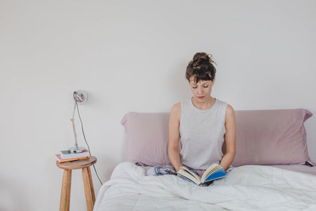 “Grey upholstered bed paired with white and natural wood bedside tables, creating a soft and balanced bedroom color palette.”