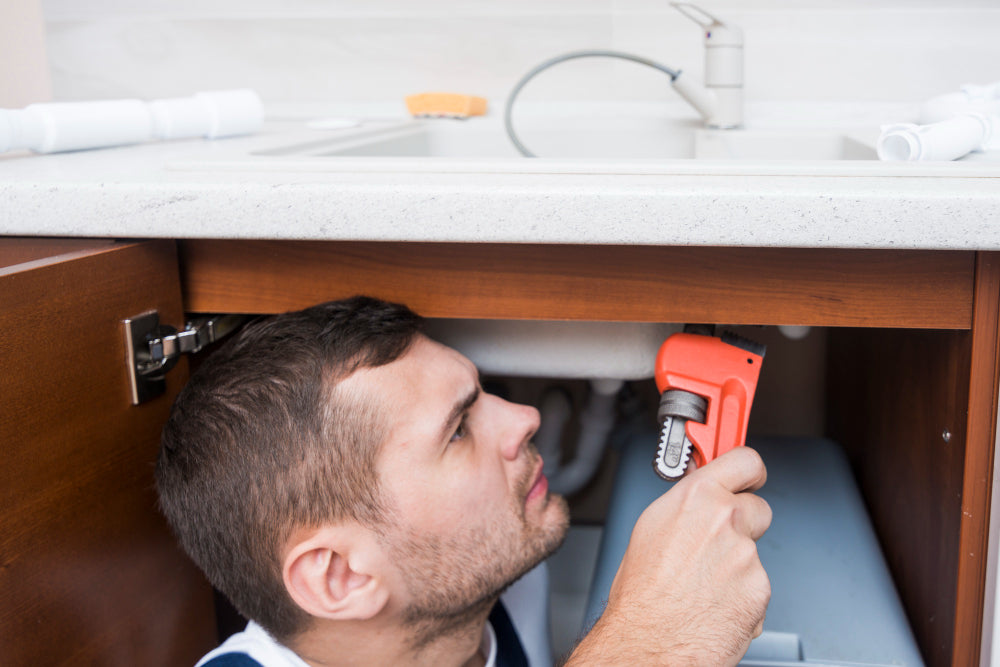 “Old bathroom vanity being removed and replaced with a modern unit, showing plumbing disconnection and cabinet installation.”
