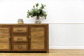 “Wooden buffet furniture with cabinet doors and drawers, used for dining room storage and surface display.”