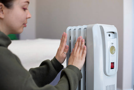 “Oil-filled radiator heater with glowing indicator light, radiating steady warmth through heated oil sealed inside its fins.”