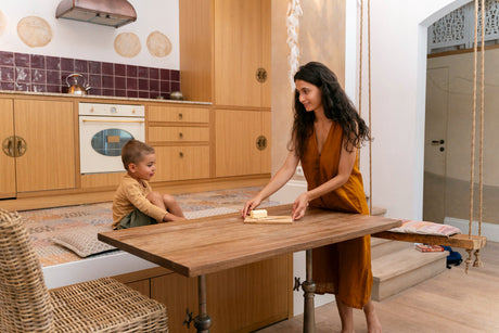 “Dining table materials including wood, glass, and marble with care products and tools arranged for maintenance guidance.”