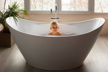 “Modern bathroom with a freestanding bathtub, styled with towels and bath accessories—representing expert answers to common tub-related questions.”