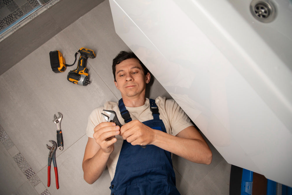 “Homeowner installing a freestanding bathtub, aligning the plumbing and securing the base in a modern bathroom.”