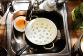 “Person pouring baking soda and lemon juice down the kitchen sink drain to eliminate bad odors naturally.”