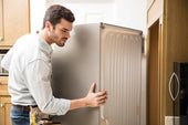 “Modern kitchen with a stainless steel refrigerator, highlighting the average appliance lifespan of 10 to 20 years depending on usage and maintenance.”