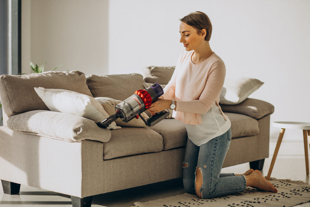 “Person cleaning a fabric sofa using a soft brush and upholstery cleaner to remove stains and refresh the fabric.”