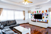 “TV cabinet styled with decorative items including books, vases, candles, and greenery arranged to frame the screen without cluttering the space.”