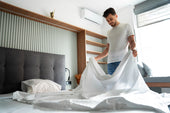 "Luxury king size mattress setup by delivery professionals in a stylish bedroom, emphasizing comfort, convenience, and promotional savings."