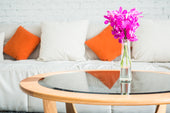 “Round coffee table styled with a decorative tray, stacked books, a candle, and a small plant arranged in a balanced triangular layout.”