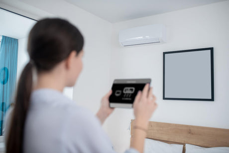 “Air conditioner operating in a room while extracting excess moisture from the air, helping reduce indoor humidity levels.”
