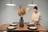 “Properly set dining table with plates, cutlery, glassware, and napkins arranged for a formal meal.”