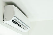 “Diagram of an air conditioner showing how warm air is drawn in, cooled by refrigerant coils, and blown back out to lower indoor temperature.”