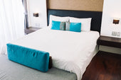 “Couple relaxing on a queen size bed with soft bedding, showcasing the perfect balance of space and intimacy a queen mattress provides.”
