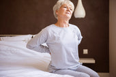 “Orthopedic memory foam mattress topper placed on a bed to relieve lower back and hip pressure for improved spinal alignment.”