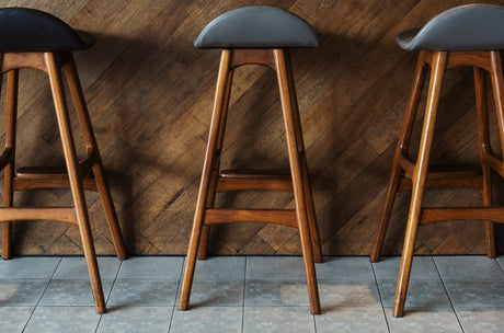 "A set of stylish bar stools perfectly matched to a modern kitchen island, highlighting coordinated colors and materials with the bar table."