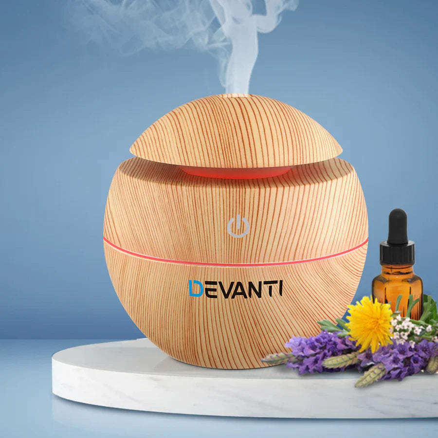 "Ultrasonic humidifier emitting visible mist from its top, showing water tank and control knobs, illustrating how the device adds moisture to the air by creating fine water droplets."