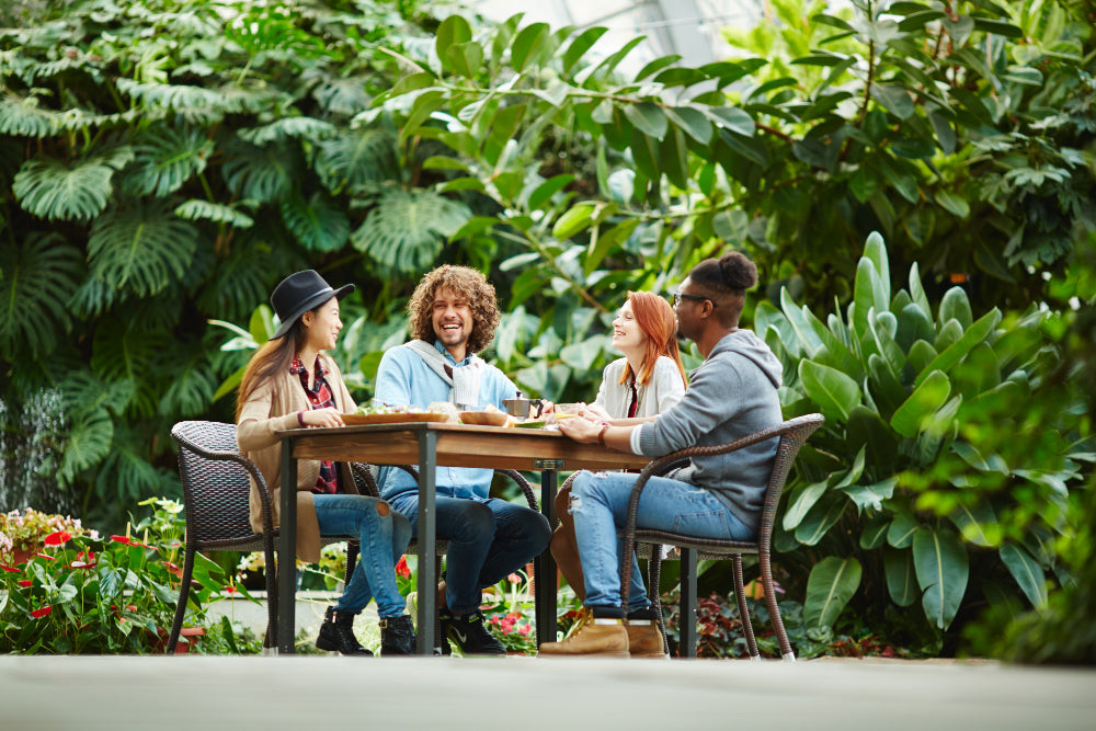 "Stylish outdoor dining set on a patio, featuring weatherproof materials like powder-coated metal and treated wood, ideal for all-season durability."