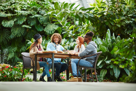"Stylish outdoor dining set on a patio, featuring weatherproof materials like powder-coated metal and treated wood, ideal for all-season durability."