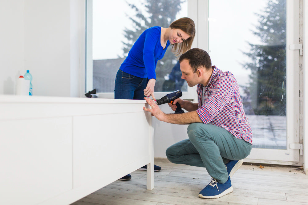"Person using a measuring tape to check bathroom dimensions, with vanity unit placement marked out, illustrating how to plan for a perfect fit."