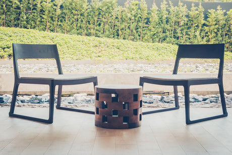  "Person assembling a modern outdoor chair on a patio, with tools and labeled parts neatly arranged for a quick and easy setup."