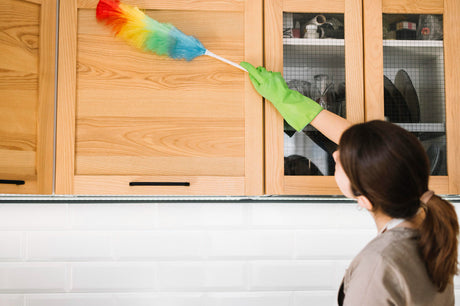 "Person gently wiping down a bathroom vanity unit with a microfiber cloth, demonstrating routine cleaning and care to preserve finish and functionality."