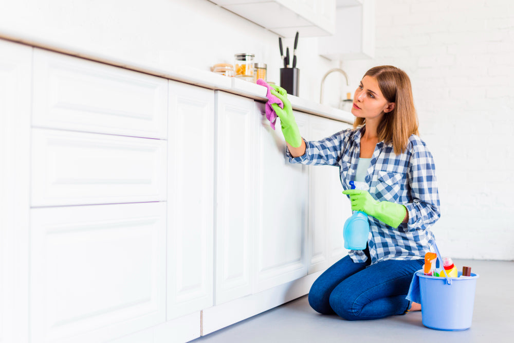 "Person wiping down a bathroom cabinet with a cloth, demonstrating simple cleaning techniques for lasting shine and condition."
