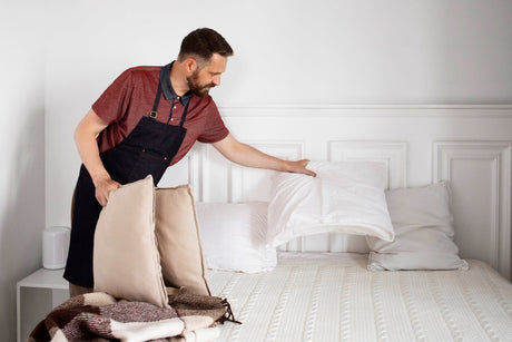 "Person vacuuming a double mattress in a bright bedroom, demonstrating cleaning and care tips to maintain freshness and longevity."