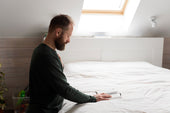 "King size mattress in a showroom with info tags highlighting key buyer concerns like firmness, size, support, and materials."