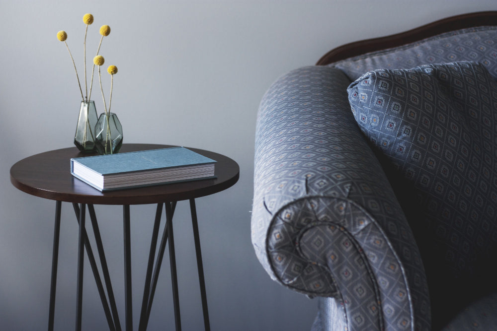 "Various side tables used in different settings—beside a sofa, bed, and in a hallway—showcasing their multifunctional design and adaptability in home decor."