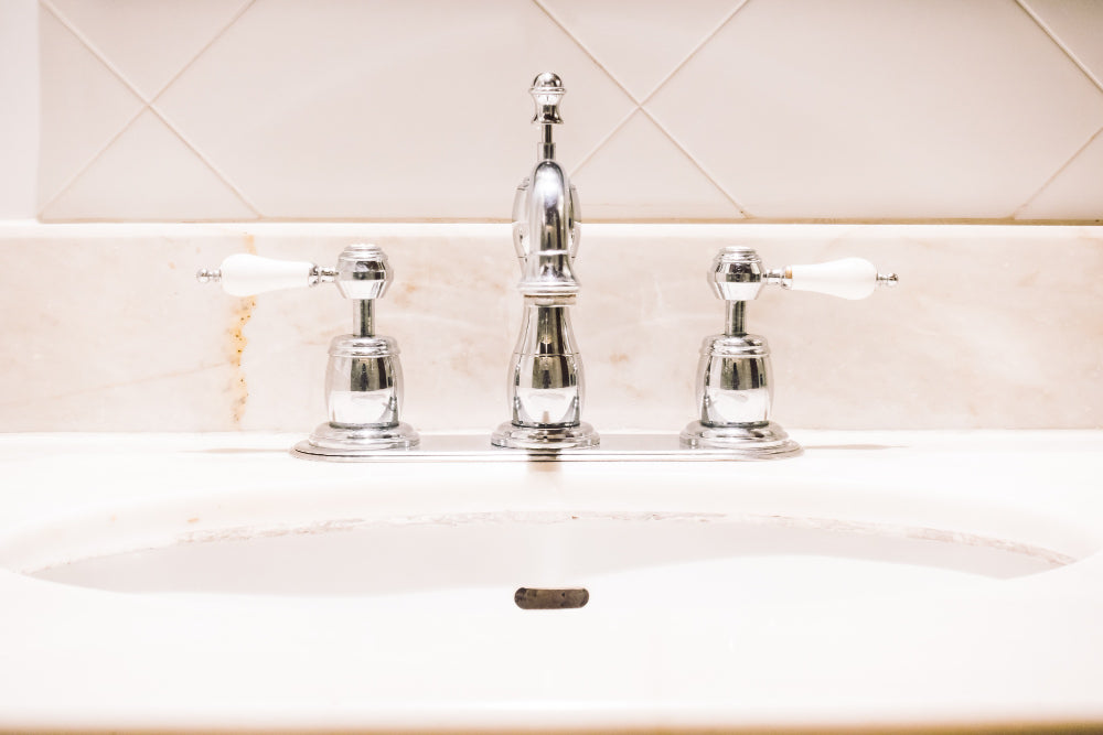 "Person polishing a chrome tap with a soft cloth, showing tips for maintaining shine and preventing buildup."