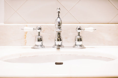 "Person polishing a chrome tap with a soft cloth, showing tips for maintaining shine and preventing buildup."