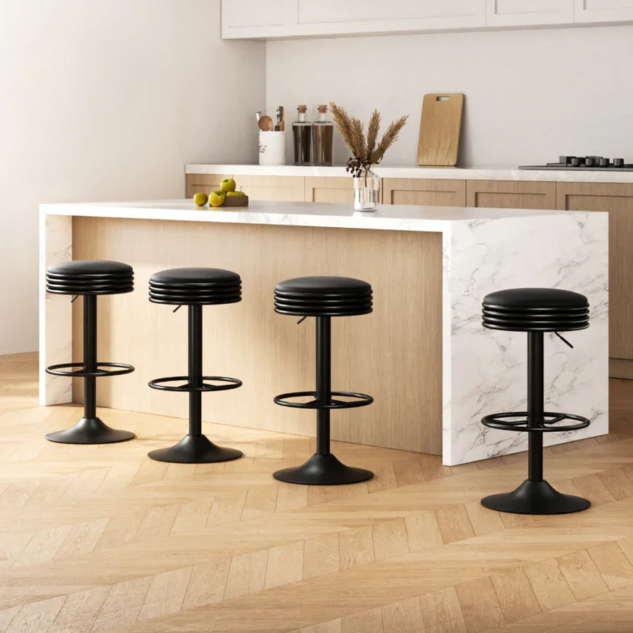 "A person measuring the height of a kitchen counter with a tape measure to choose the correct bar stool height, with stools of varying sizes nearby."