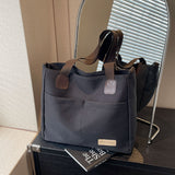 Stylish black canvas tote bag with detachable shoulder strap