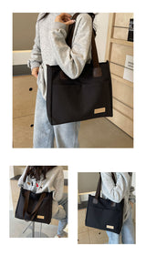 Stylish black canvas tote bag with detachable shoulder strap - Front View